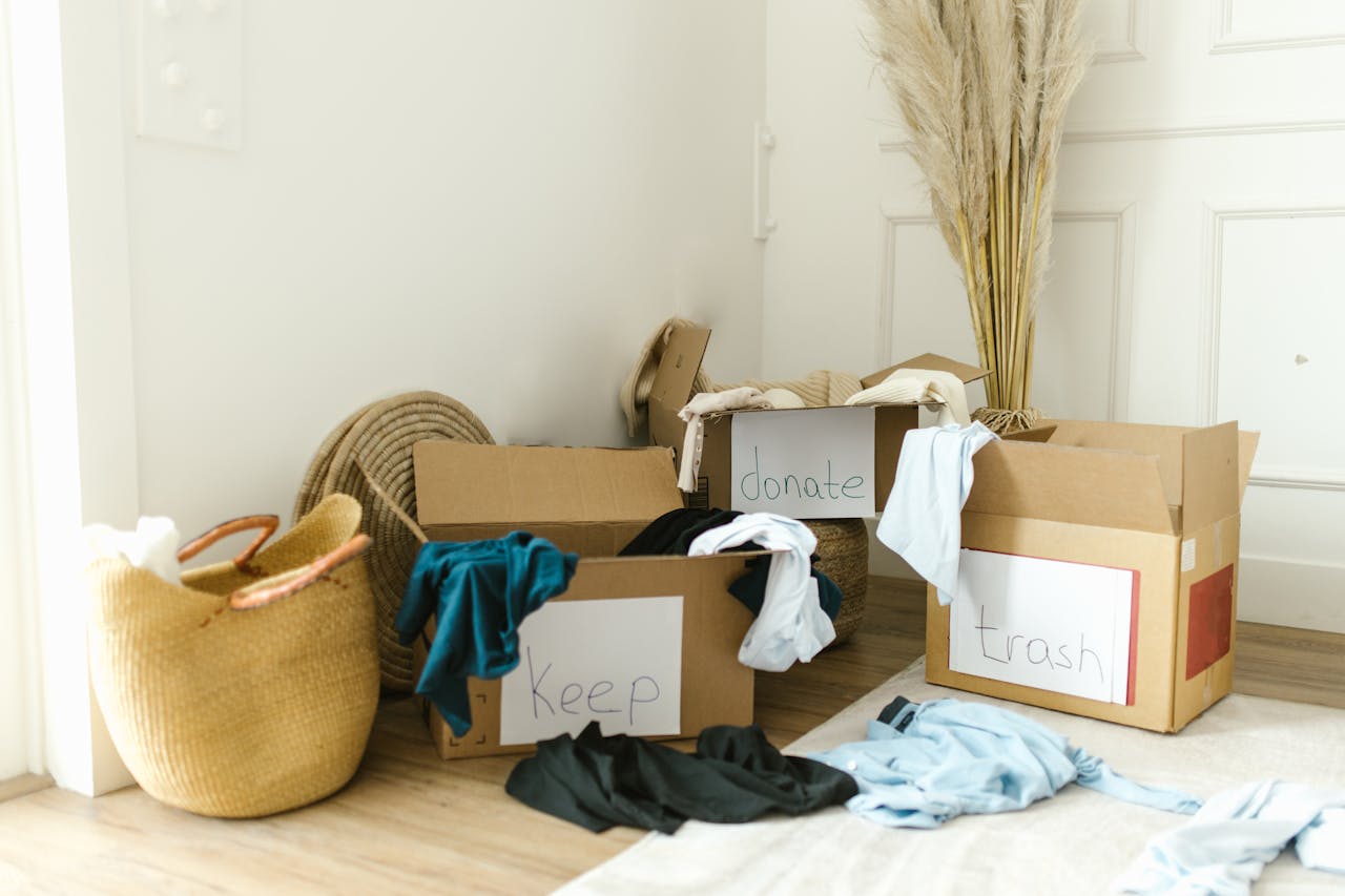 Cardboard boxes labeled Keep, Donate, and Trash for home decluttering.